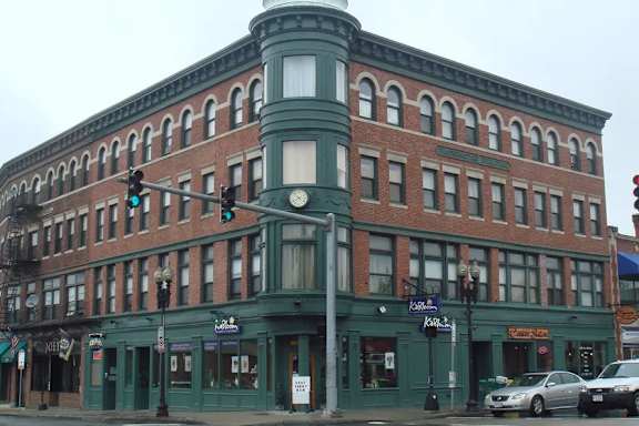 A green building with a red brick facade.