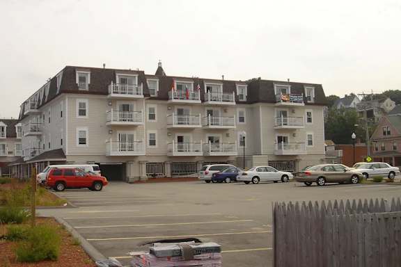 A parking lot with cars and a building in the background.