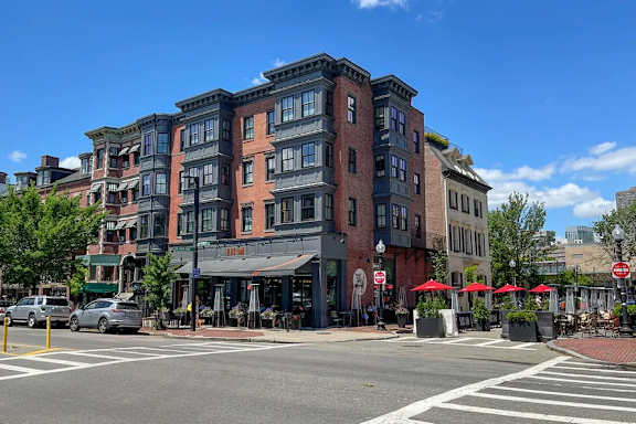A street view of a city with buildings, cars, and a crosswalk.