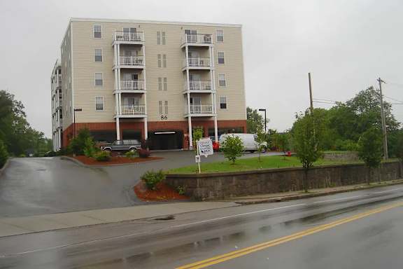 A large apartment building with a parking lot in front.