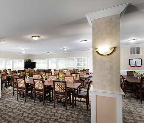 a large dining room with tables and chairs and a television