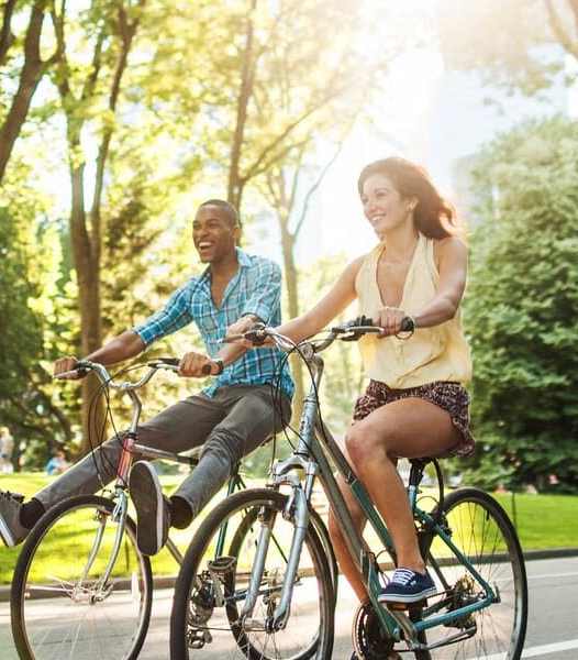 a man and a woman riding bikes down a street