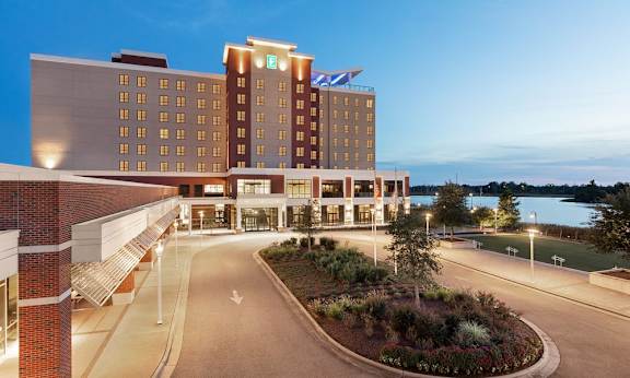 A hotel with a large front entrance and a landscaped area in front.