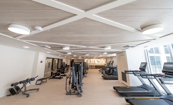a gym with treadmills and elliptical machines