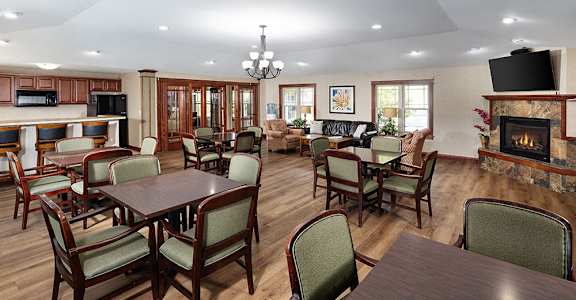 a community room with tables and chairs and a fireplace