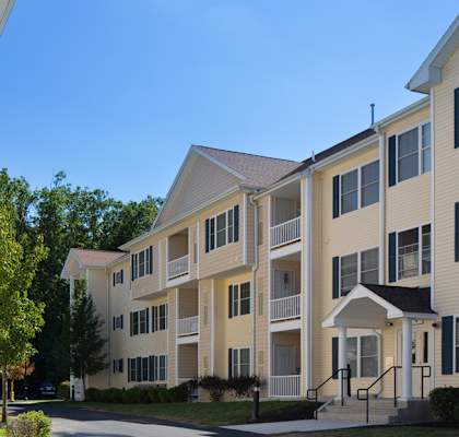 a street view of an apartment complex with trees in the background