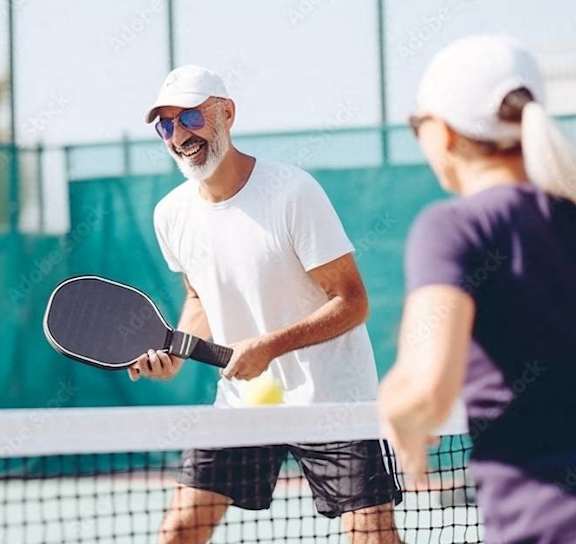 a man and a woman playing tennis on a court at The Levi Luxury Apartments, Georgia