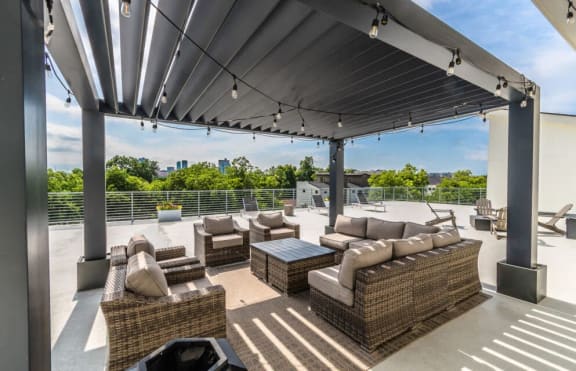 a patio with couches and tables on a roof