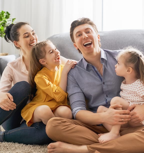 a family sitting on the floor in a living room