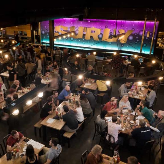 a crowd of people sitting at tables in a restaurant