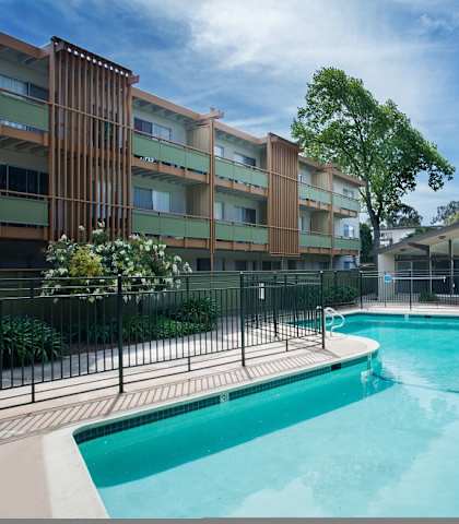 a pool with a fence around it in front of a building