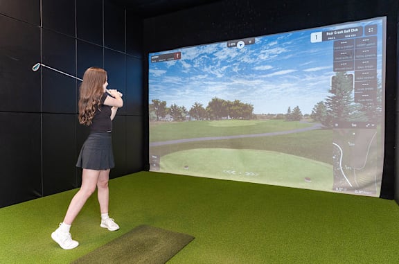 A woman is playing a golf game on a screen.