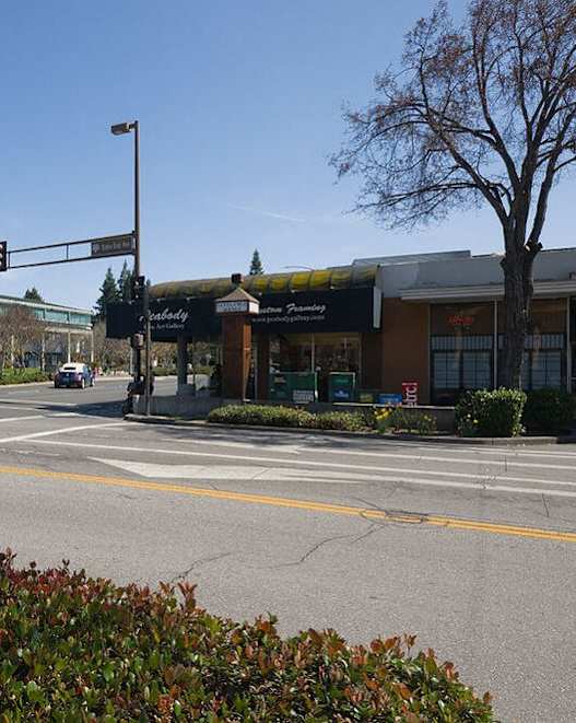 A street view with a traffic light and a car on the road.