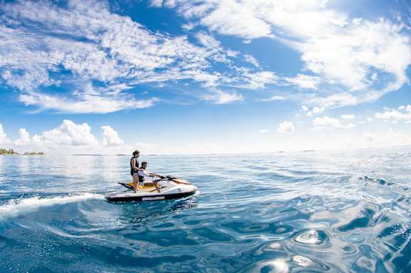 Two people are riding a jet ski on the water.
