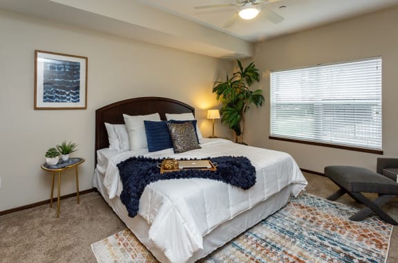 large master bedroom with big windows and high ceilings