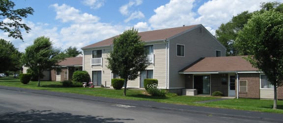 a house with a yard and a fountain in front of it