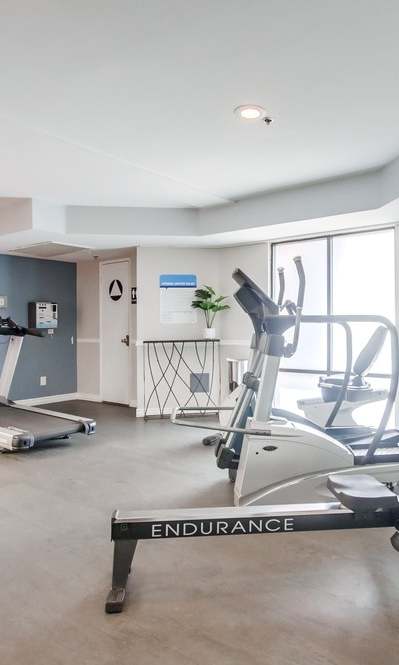 A gym with treadmills, elliptical machines, and a stationary bike.