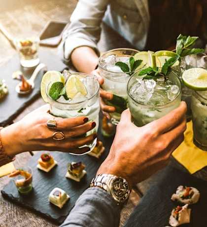 Group of people holding up cocktails at a table at Lexington on the Green, North Carolina, 27604