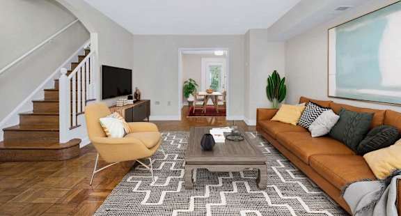 A living room with a brown couch, a yellow chair, and a patterned rug.