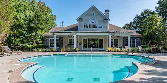 A house with a pool in front of it.