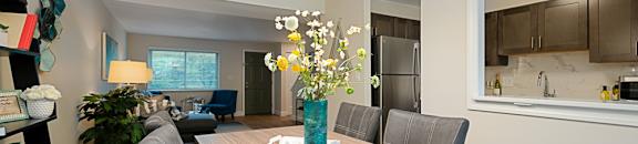 a dining room table with a vase with flowers on it