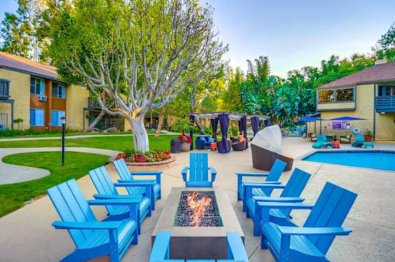 a group of blue lounge chairs around a fire pit