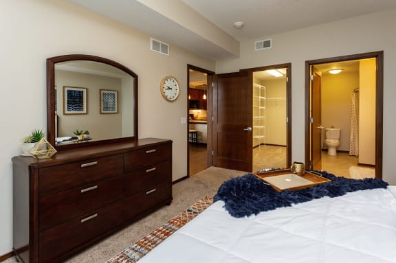 view of doors within bedroom leading to large walk-in closet, master bathroom, and living room area