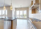 Thumbnail 1 of 13 - A penthouse with large island and stainless steel appliances.