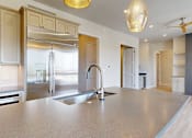 Thumbnail 3 of 13 - A modern penthouse kitchen with a large island and stainless steel appliances and a large island.