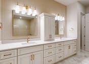 Thumbnail 12 of 13 - Penthouse primary bathroom with dual vanities and custom built-in cabinetry