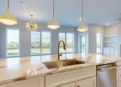 Thumbnail 10 of 13 - A kitchen with a marble countertop and a large windows.