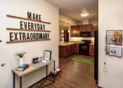 Thumbnail 6 of 26 - entryway into apartment unit with sign 'Make Everyday Extraordinary' and view into the kitchen