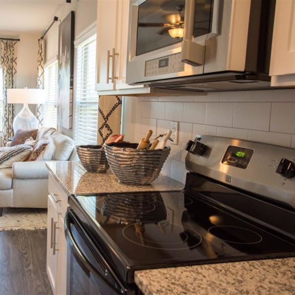 a kitchen with a stove and a living room with a couch