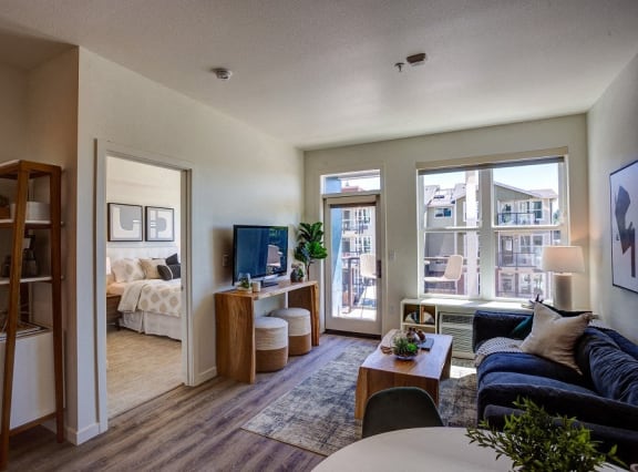 a living room with a couch and a table and a window at Commons at Sylvan Canyon Apartments, Portland, OR, 97221