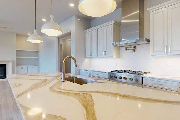 A modern kitchen with a quartz countertop and premium stainless steel appliances.