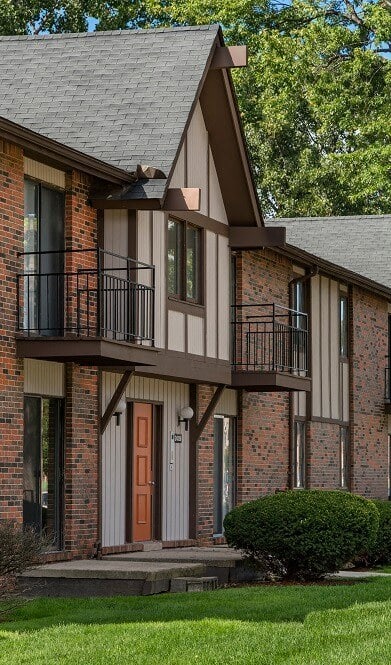 a view of a building with a lawn and trees