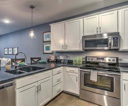 Large open floor plan kitchen with white cabinetry and stainless steel appliances