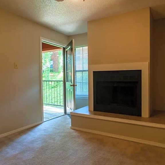 a living room with a fireplace and a door to a patio