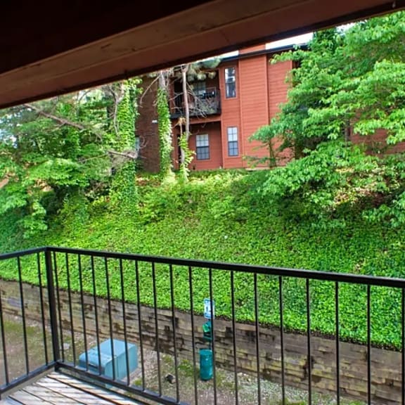 a balcony with a view of trees and a brick building