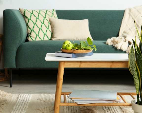 Living room with a green couch and a coffee table with a bowl of fruit at Lexington on the Green, Raleigh, 27604