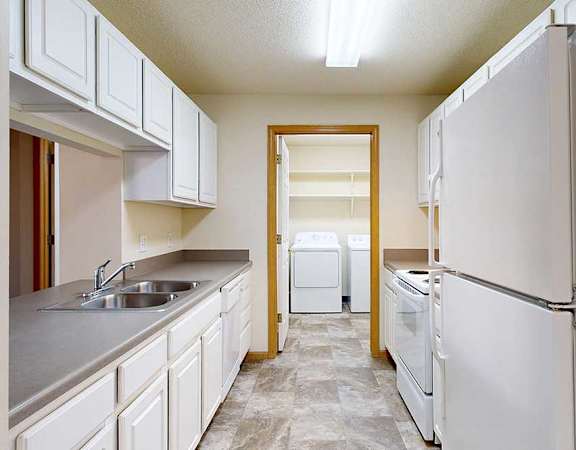 A kitchen with white appliances and cabinets.