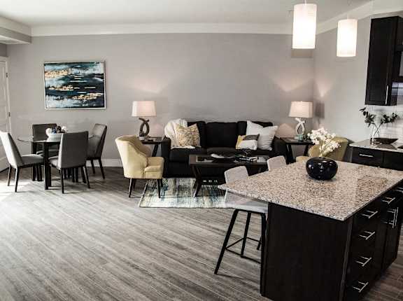 A modern living room with a grey carpet and a black and white sofa at Avonlea in Lakeville, MN