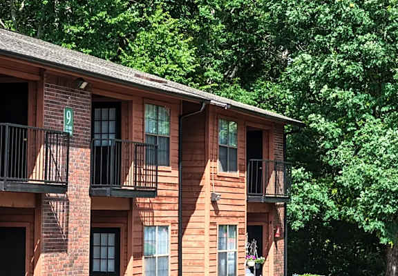 a brick apartment building with balconies and trees