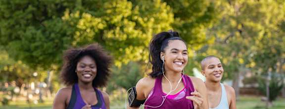 Three women jogging in a park.