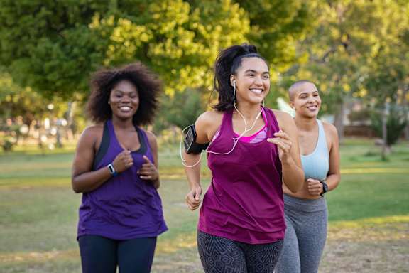 Three women jogging in a park.