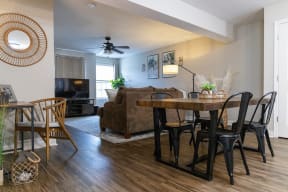 a living room and dining room with hardwood floors and a ceiling fan