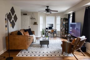 a living room with a brown couch and a tv