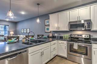 Large open floor plan kitchen with white cabinetry and stainless steel appliances