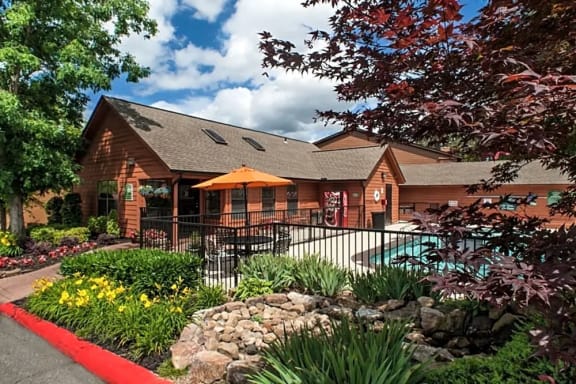a house with a pool and a garden in front of it