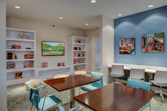 a dining room with tables and chairs and a bookshelf and paintings